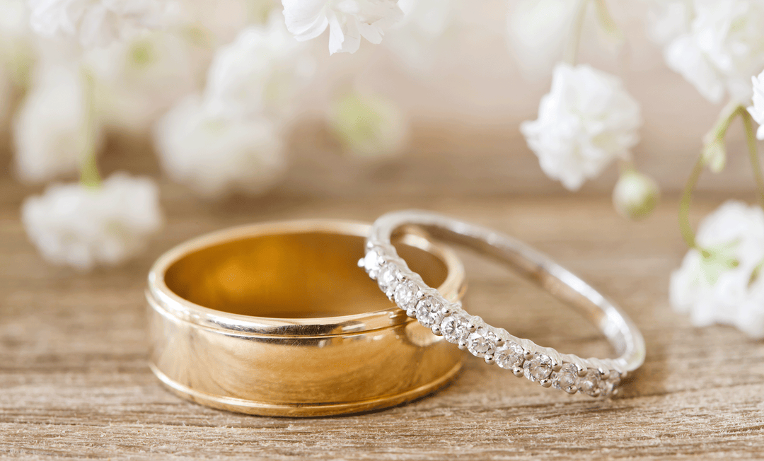 His and her yellow gold wedding band. A plain, wide men's band and a smaller diamond eternity band ring.