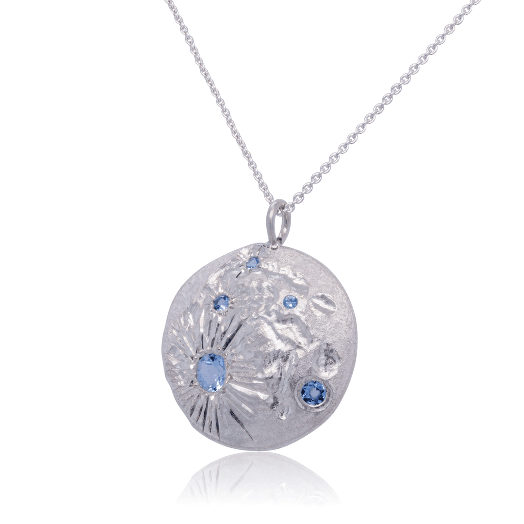 Artistic Luna pendant in textured silver with ethically sourced blue topaz – bold jewellery for creative souls.