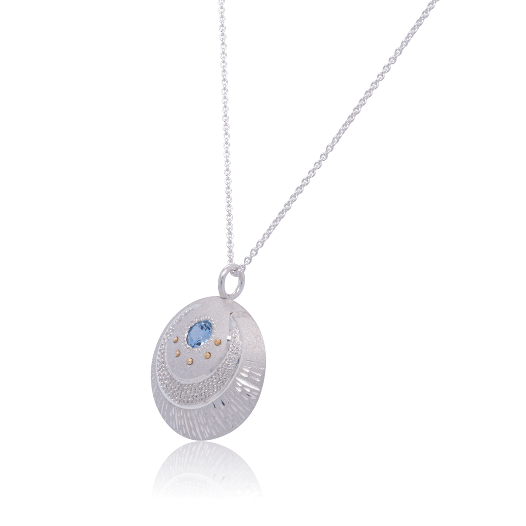 Sterling silver Luna Pendant necklace featuring crescent moon design, blue topaz gemstone, and gold accents by Janine Jewels.