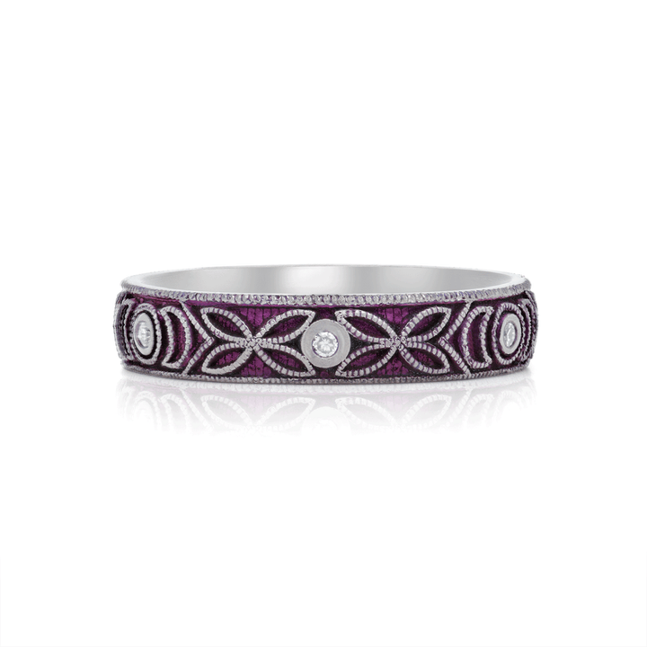 4mm titanium ring with purple anodized finish, featuring intricate floral engraving and six 1.3mm round white moissanite stones in bezel settings, designed for an active lifestyle and crafted with a blend of laser and hand engraving for a unique, vibrant look. Seen on white background