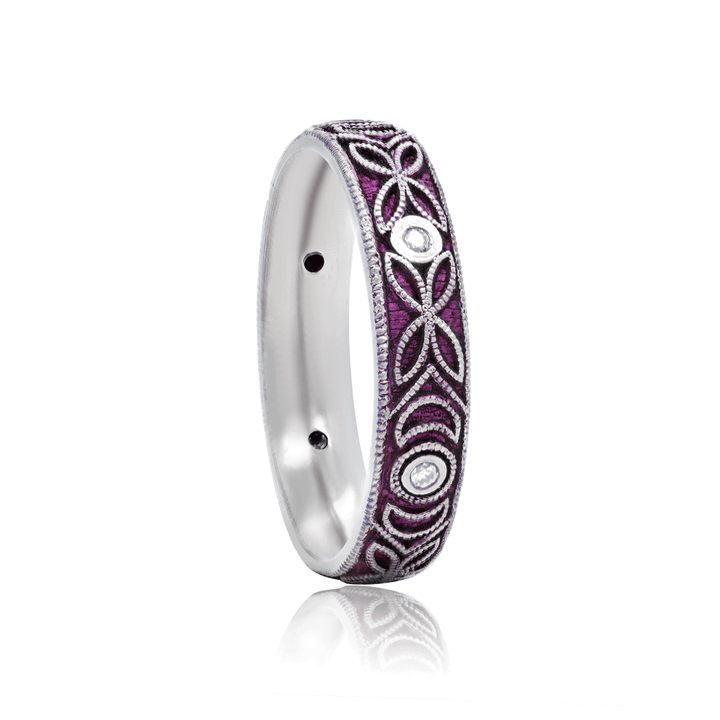 Three-quarter view of 4mm titanium ring with purple anodized finish, featuring intricate floral and moon engraving. Includes six 1.3mm round white moissanite stones in bezel settings, designed for an active lifestyle and crafted with a blend of laser and hand engraving for a unique, vibrant look. On white background.