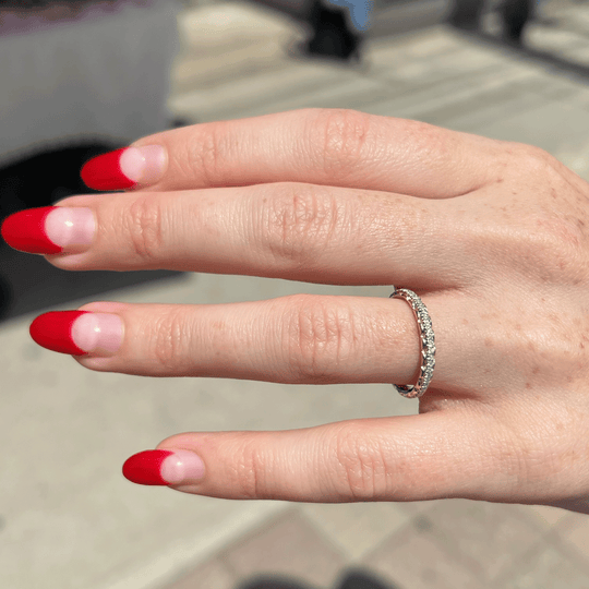 Modern 18k recycled yellow gold and white gold eternity band with lab-grown diamonds. shown on hand model.