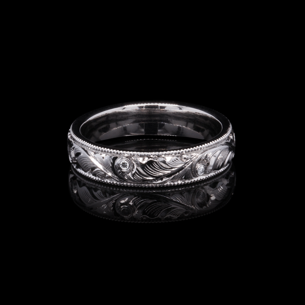 Detailed shot of a hand-engraved platinum wedding band adorned with sparkling lab-grown diamonds.